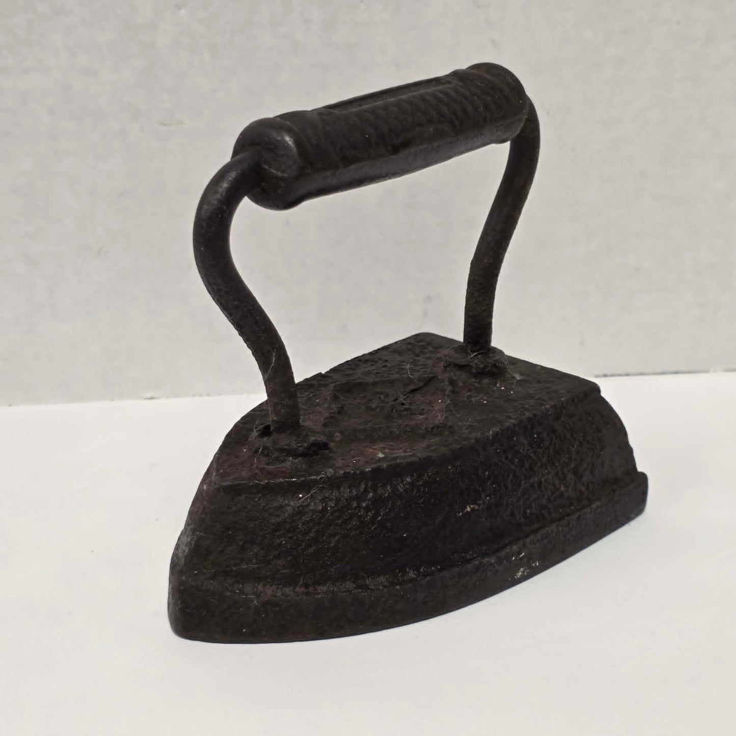 Antique Taylor Forbes No. 6 cast iron sad iron with diamond marking and patterned handle.
