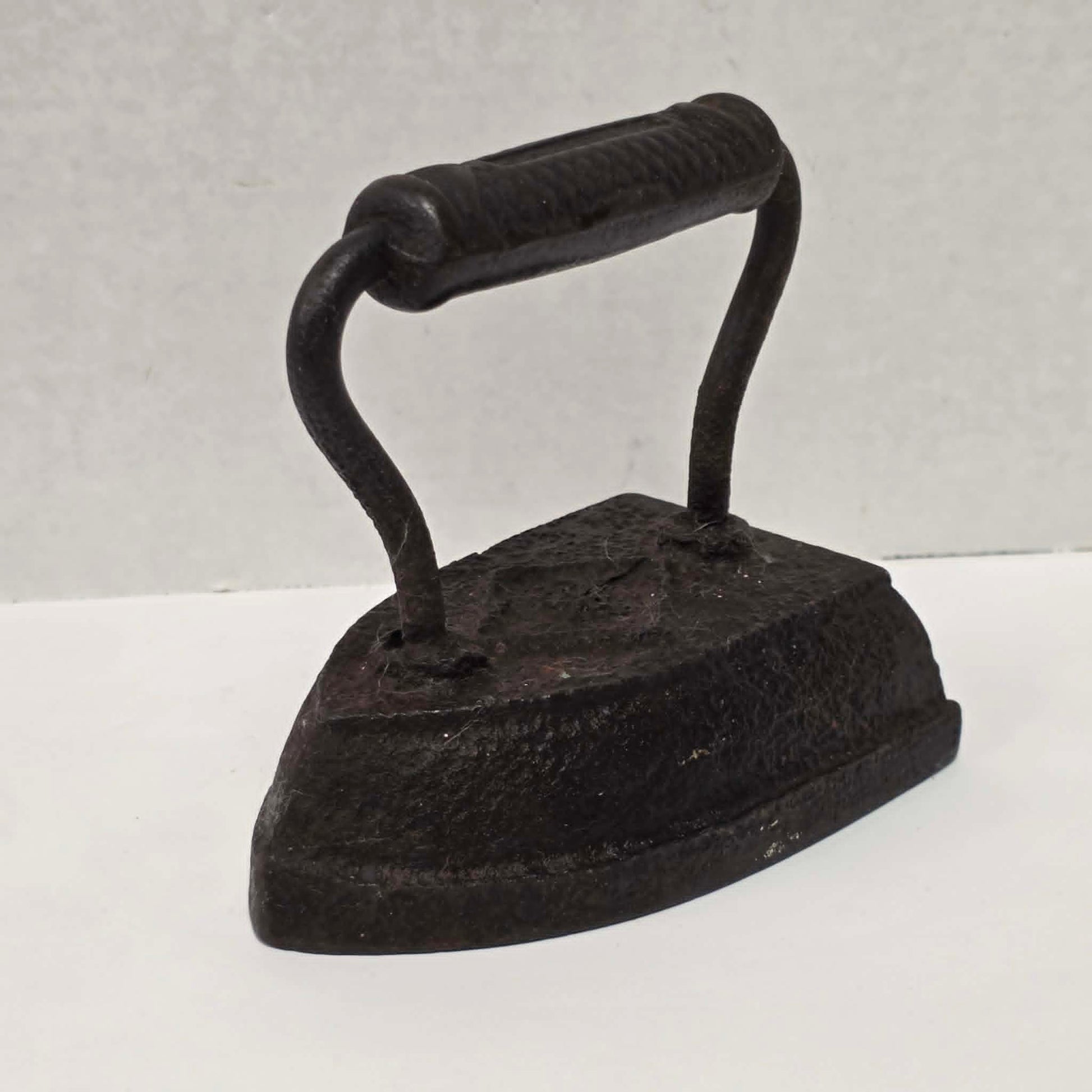 Antique Taylor Forbes No. 6 cast iron sad iron with diamond marking and patterned handle.
