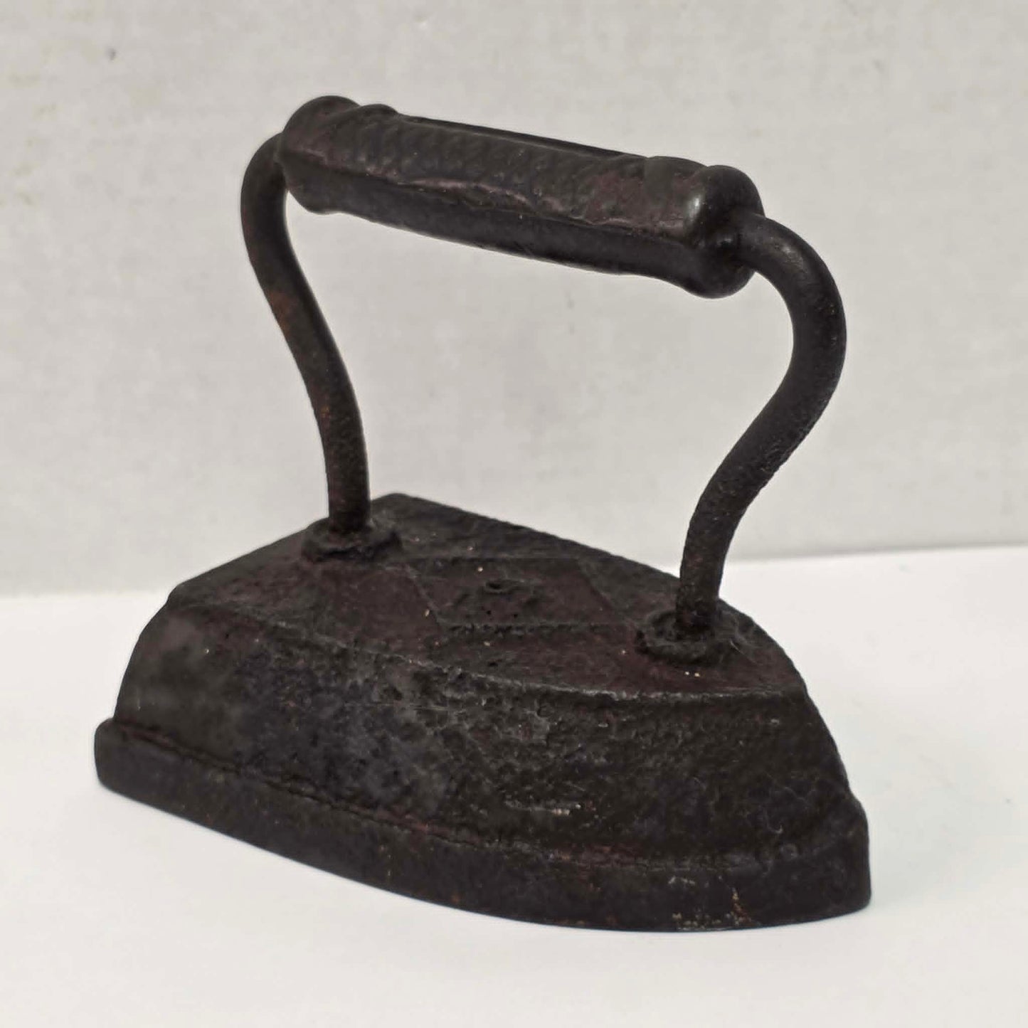 Antique Taylor Forbes No. 6 cast iron sad iron with diamond marking and patterned handle.
