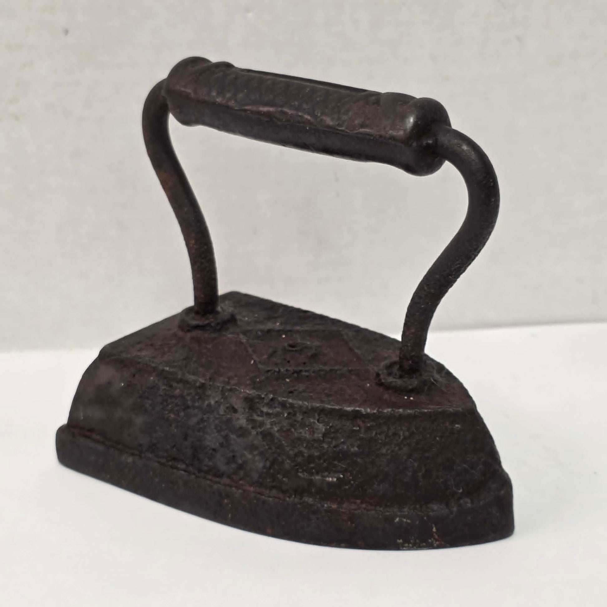 Antique Taylor Forbes No. 6 cast iron sad iron with diamond marking and patterned handle.
