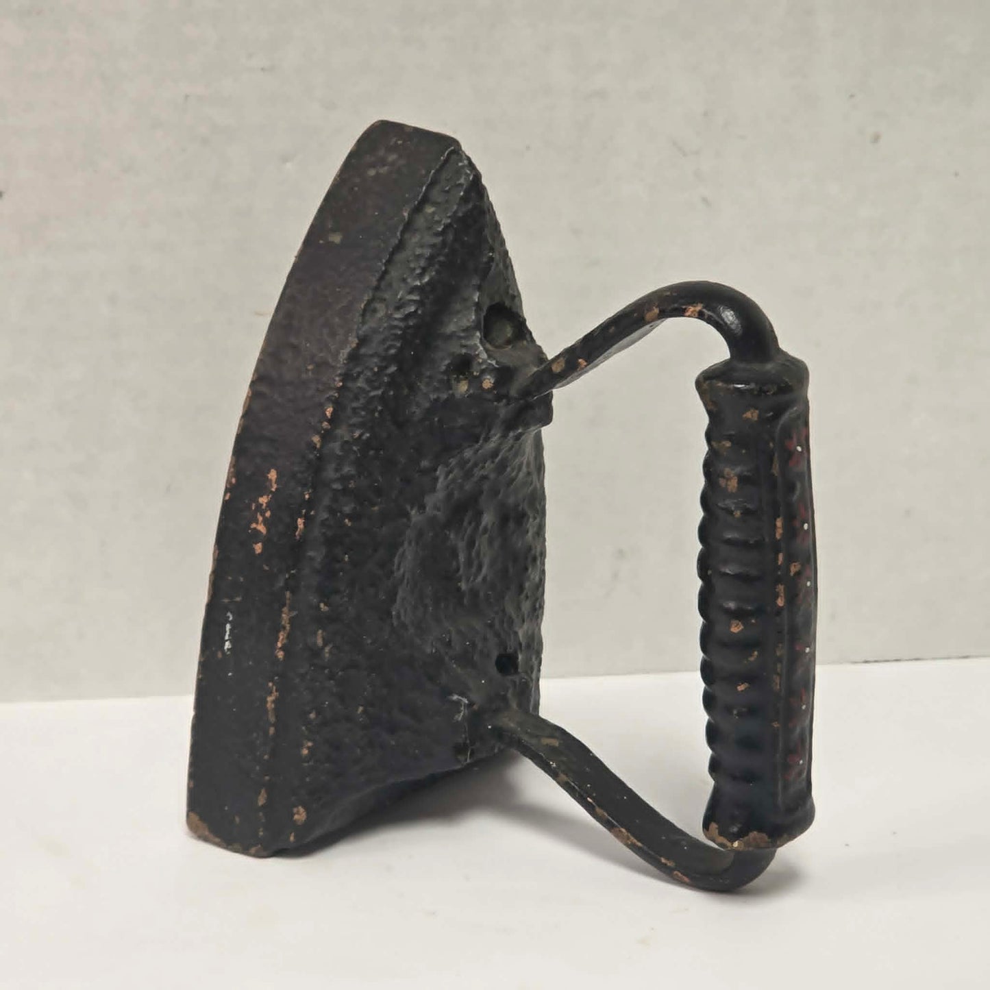 Primitive antique cast iron sad iron with nicely formed handle and vintage finish.
