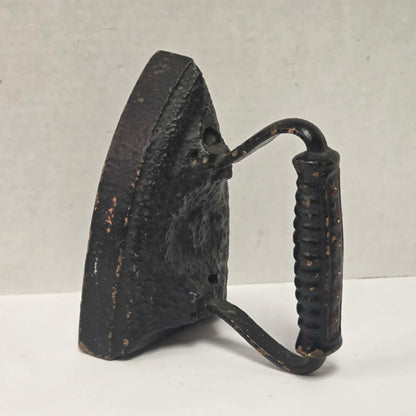 Primitive antique cast iron sad iron with nicely formed handle and vintage finish.
