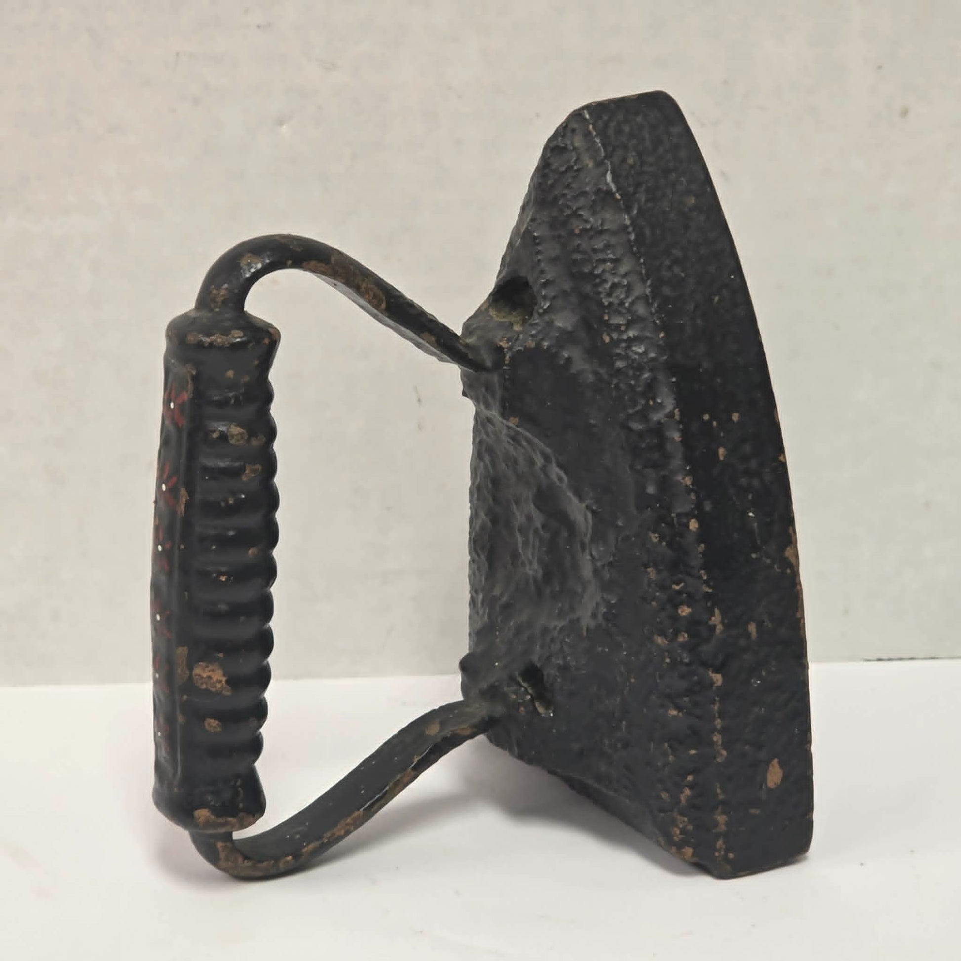 Primitive antique cast iron sad iron with nicely formed handle and vintage finish.
