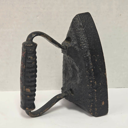 Primitive antique cast iron sad iron with nicely formed handle and vintage finish.
