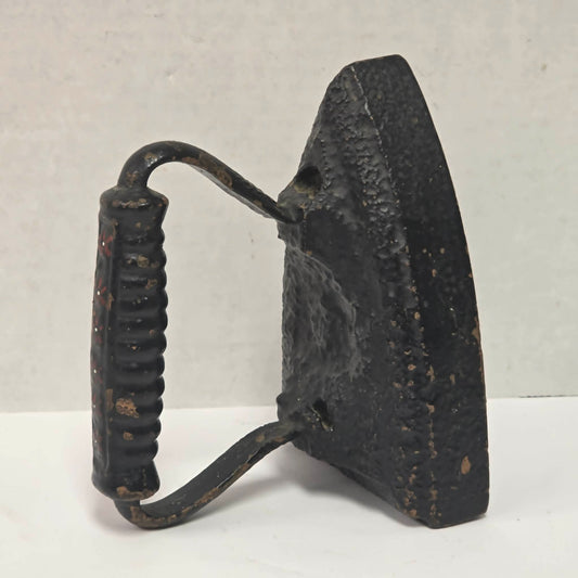Primitive antique cast iron sad iron with nicely formed handle and vintage finish.
