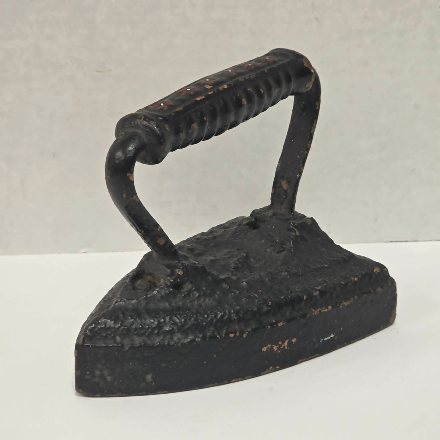 Primitive antique cast iron sad iron with nicely formed handle and vintage finish.
