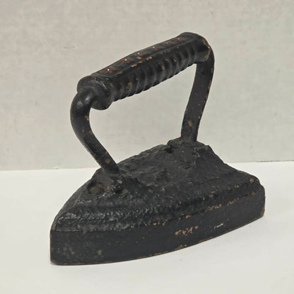 Primitive antique cast iron sad iron with nicely formed handle and vintage finish.
