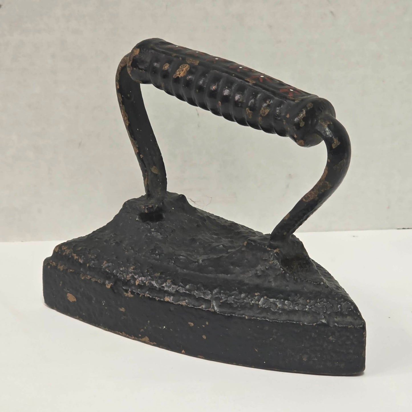 Primitive antique cast iron sad iron with nicely formed handle and vintage finish.

