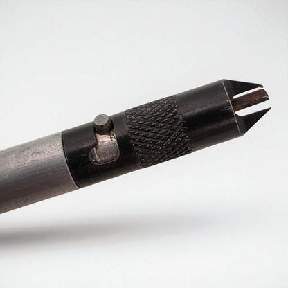 Close-up of a metal tool with a textured handle on a white background