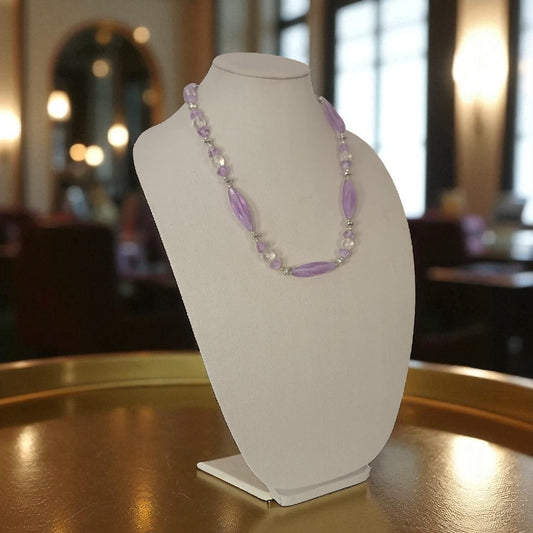 Necklace on a mannequin bust with a blurred indoor background