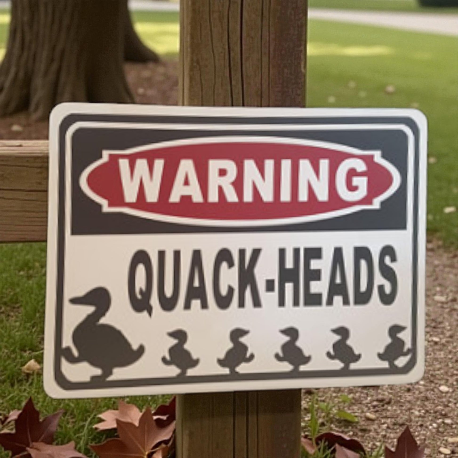 Warning sign with duck illustrations on a grassy background