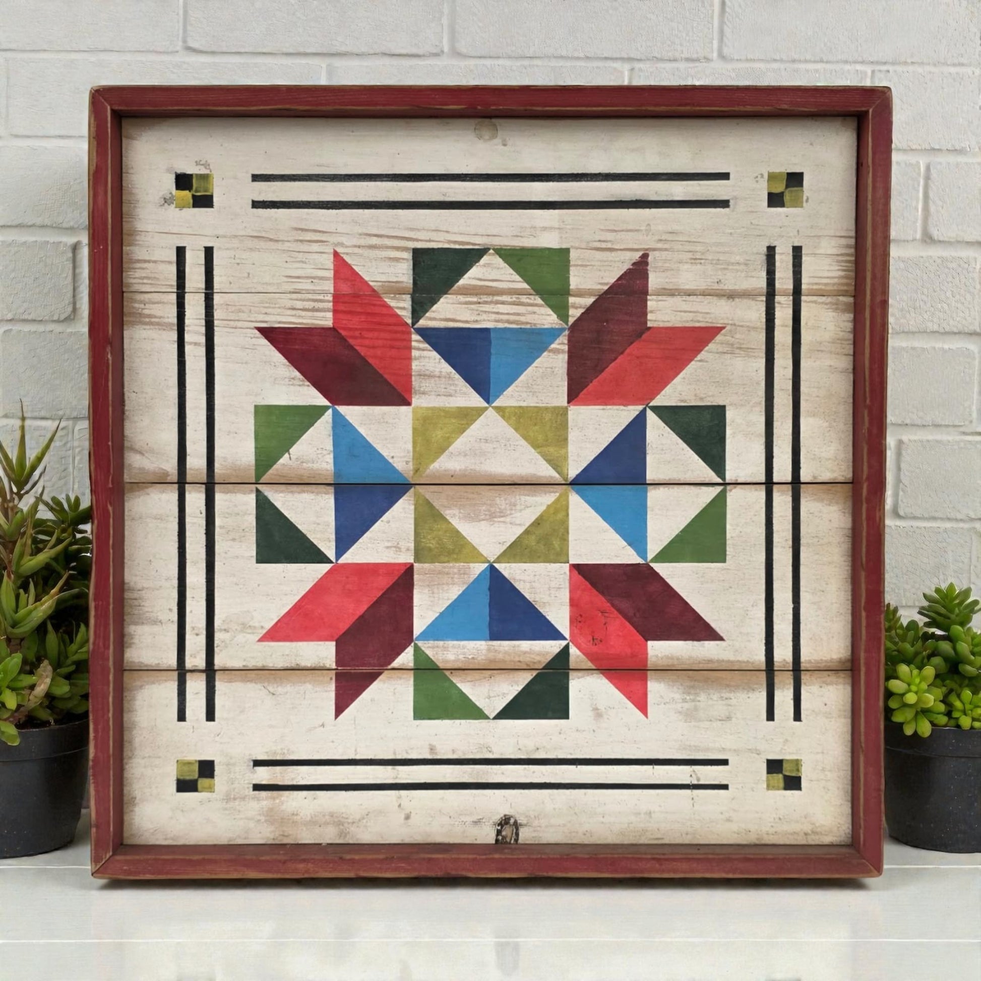 Wooden wall art with geometric pattern in a wooden frame on a white brick wall background.
