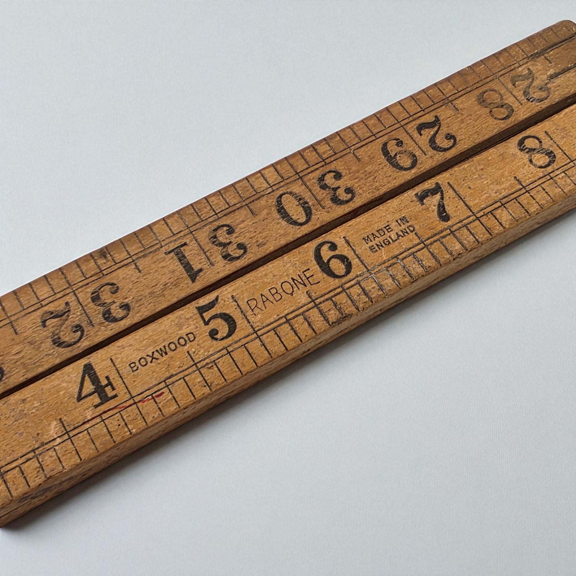 Wooden ruler with measurement markings on a light gray background