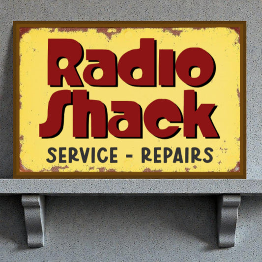 Vintage Radio Shack sign with yellow background and red text on a gray surface.