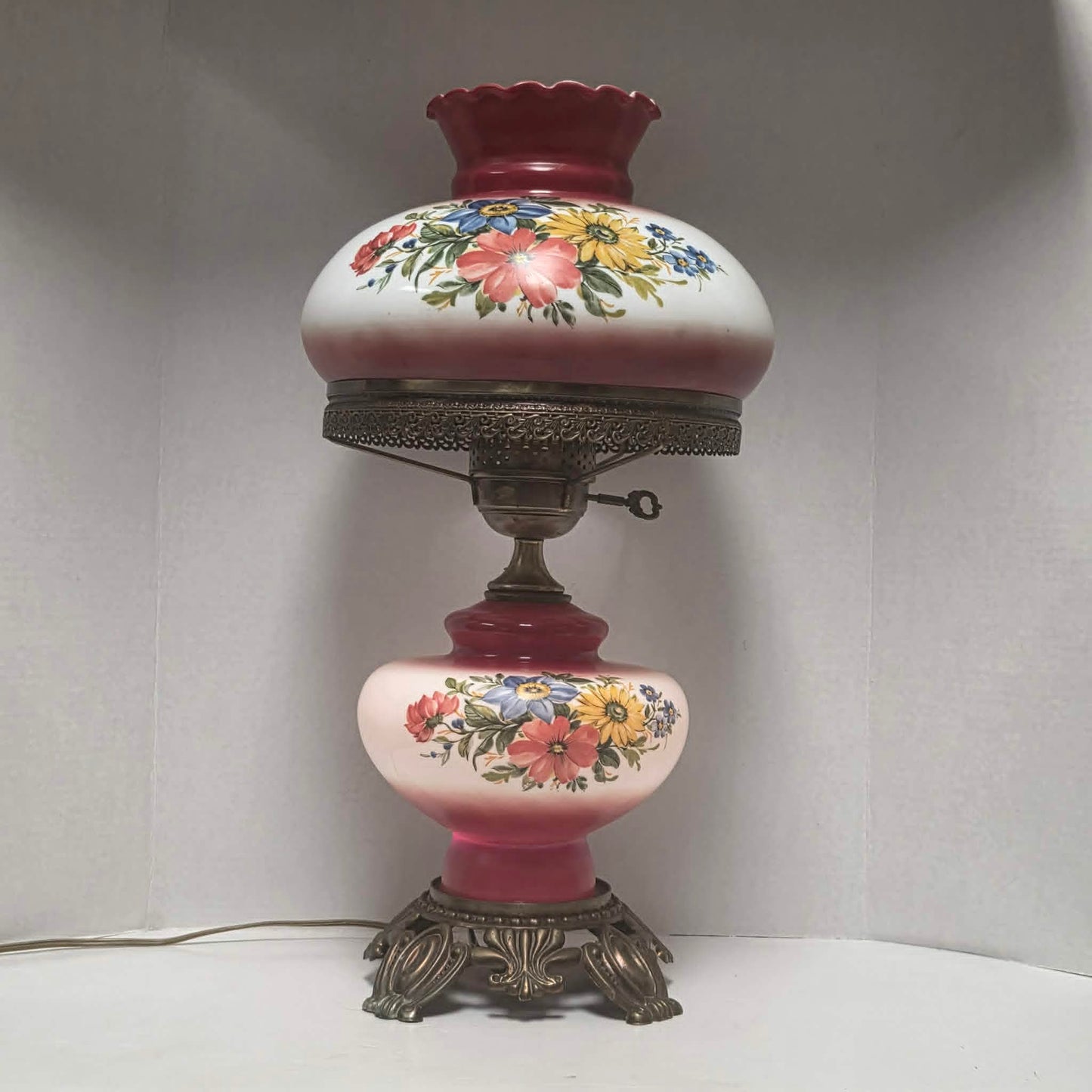 Vintage Gone with the Wind hurricane lamp with red and white floral glass and tri-light feature.
