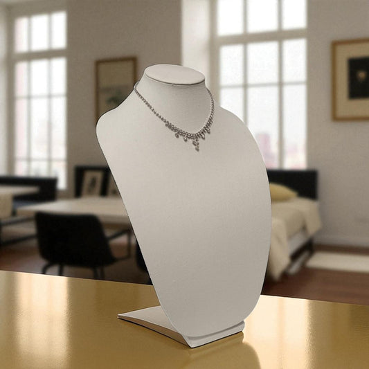 Necklace on a white bust against a blurred indoor background