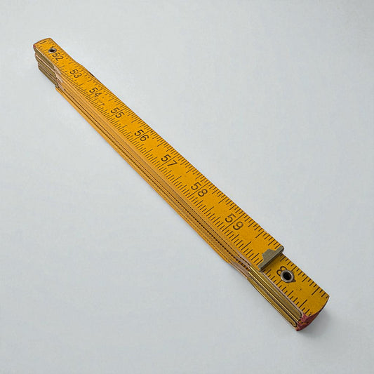 Yellow metal ruler on a white background