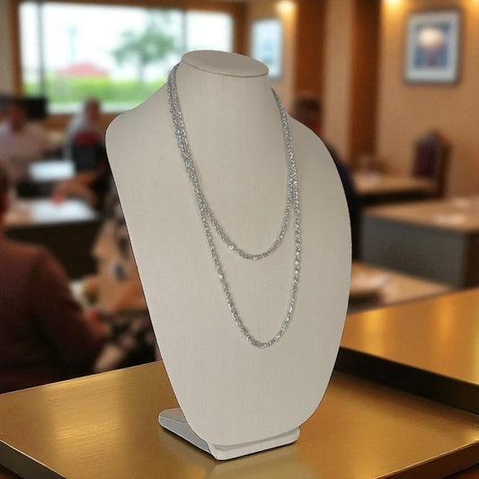 Silver necklace on a white bust display in a restaurant setting