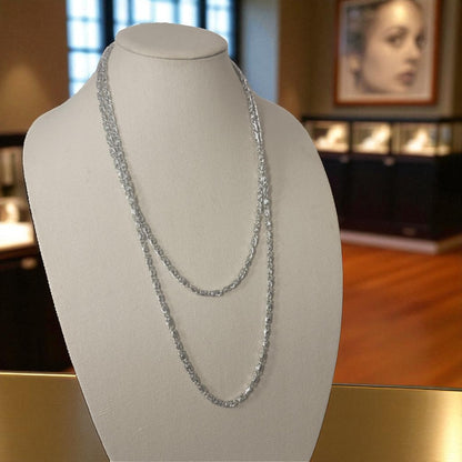 Silver chain necklace on a mannequin bust with a blurred indoor background