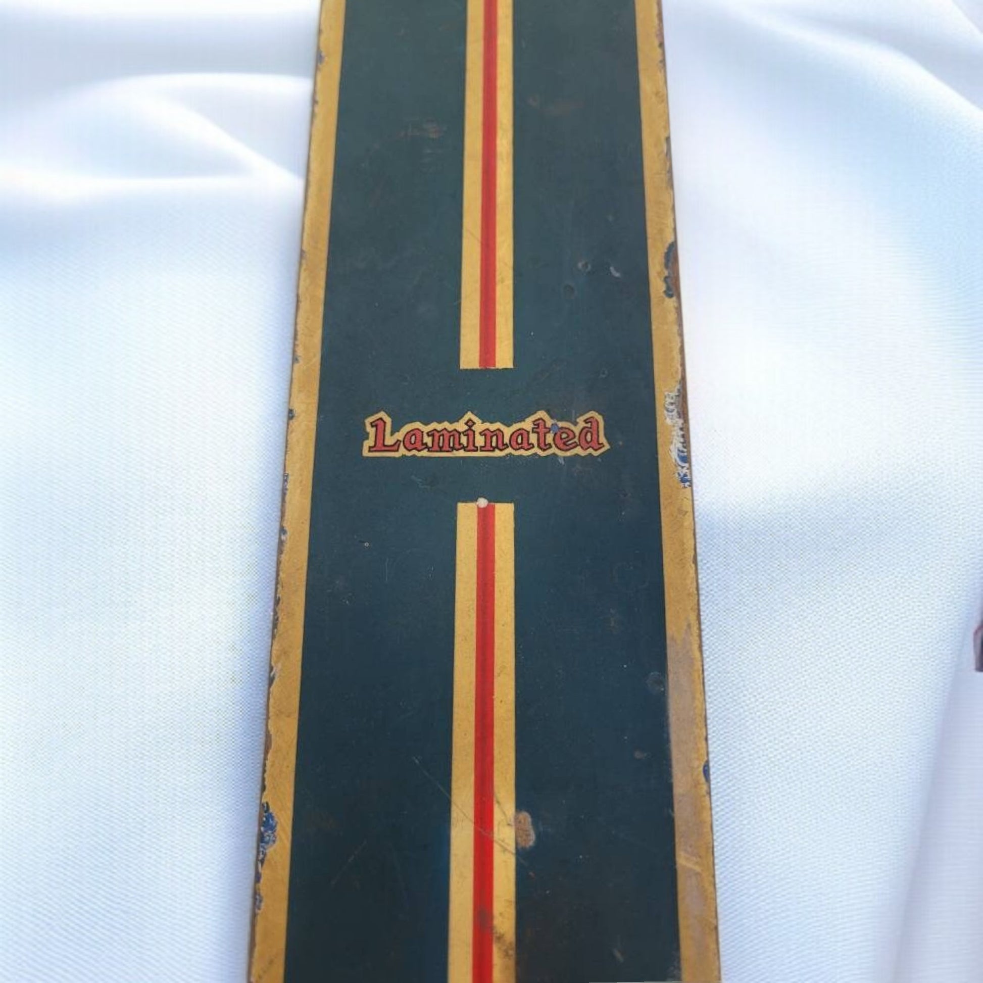 Wooden skateboard deck with 'Laminated' text on a white background