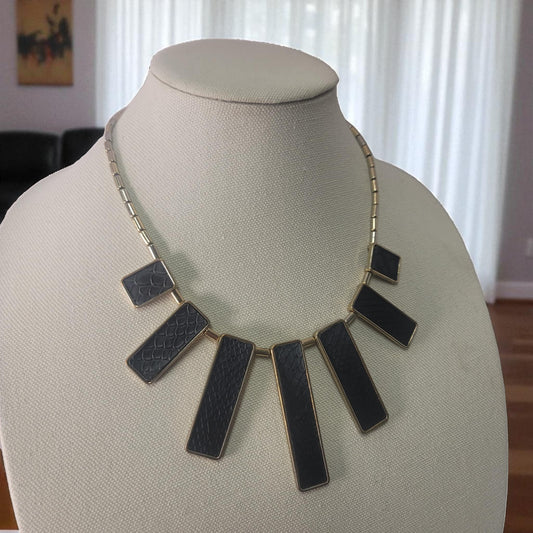 Necklace with black rectangular pendants on a mannequin bust.