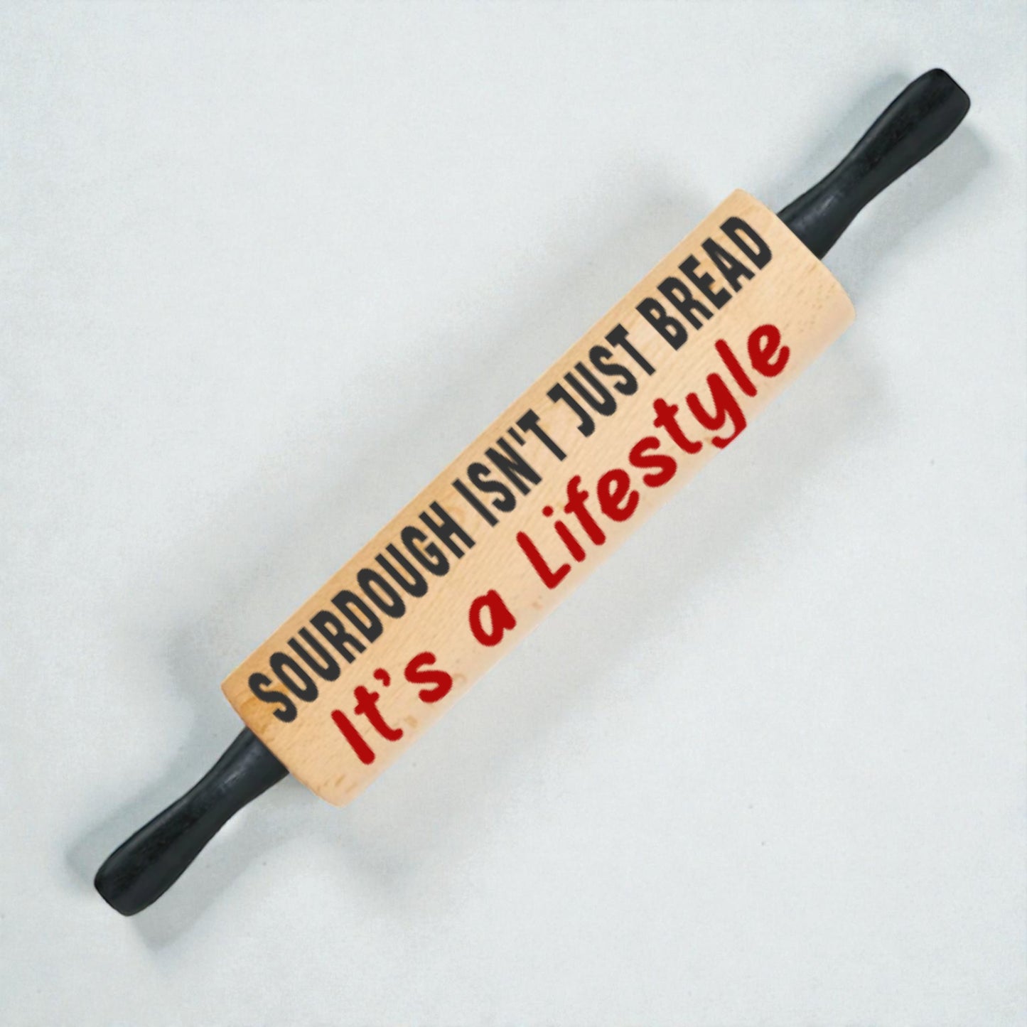 Rolling pin with text 'Sourdough isn't just bread, it's a lifestyle' on a light background