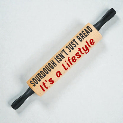 Rolling pin with text 'Sourdough isn't just bread, it's a lifestyle' on a light background