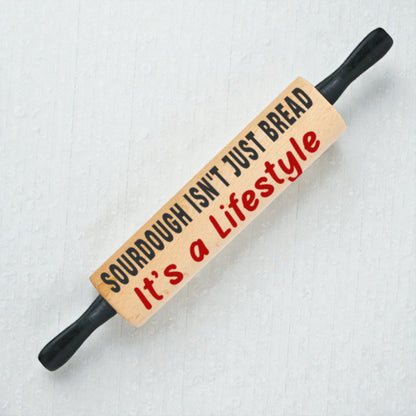 Wooden rolling pin with text on a light background