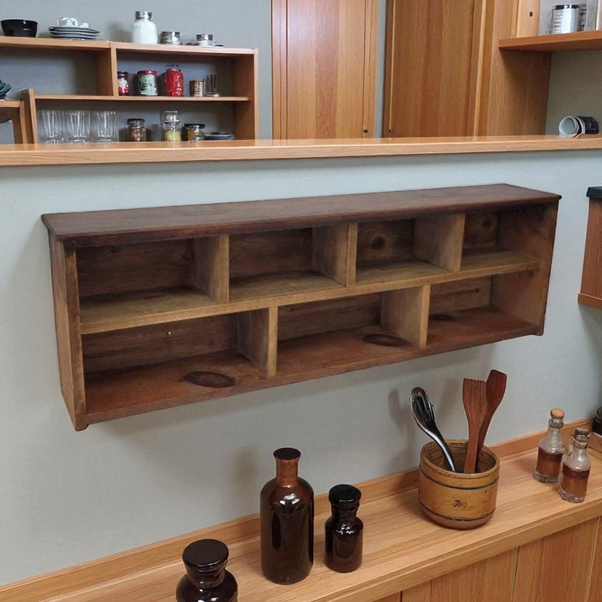 Wooden wall shelf in a kitchen setting with wooden cabinets and shelves.
