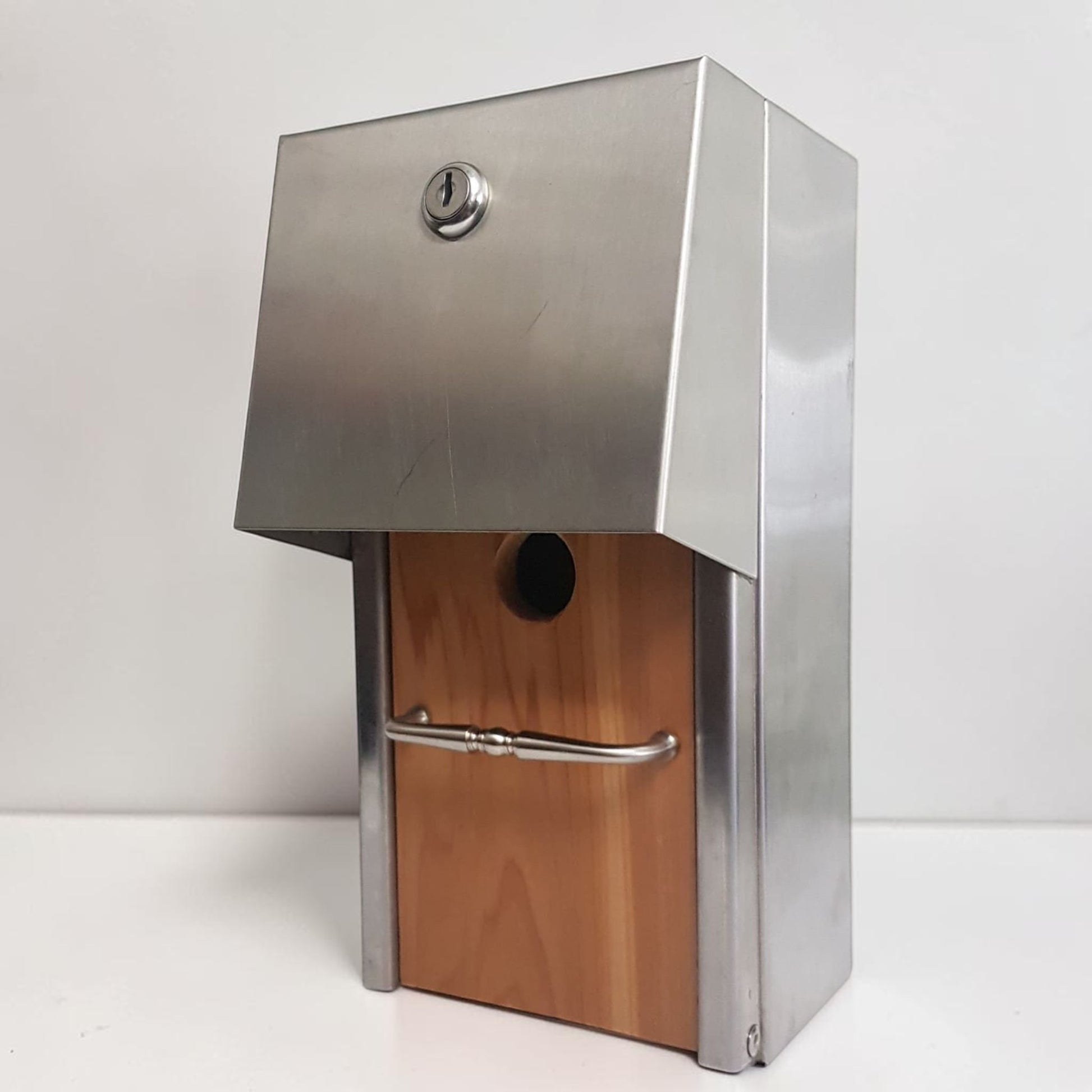 Handmade stainless steel birdhouse with sleek architectural styling and locking access door.