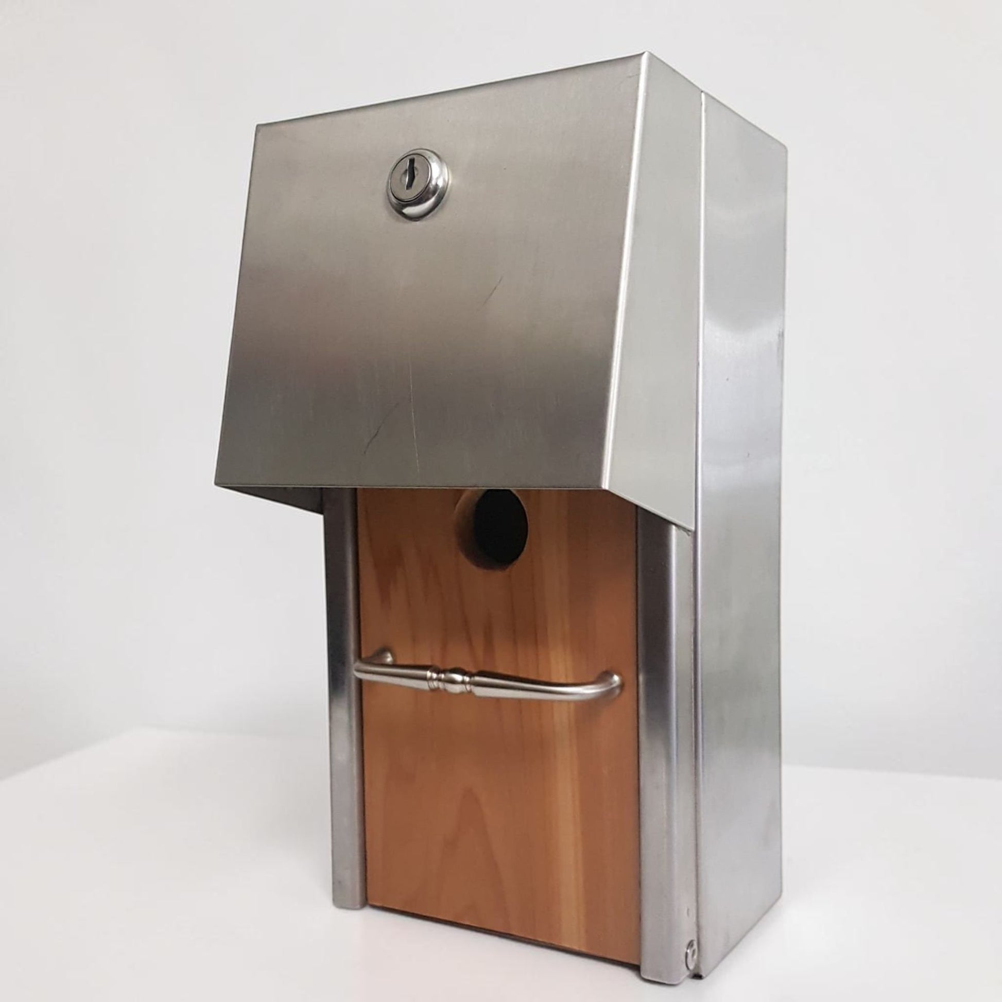 Handmade stainless steel birdhouse with sleek architectural styling and locking access door.