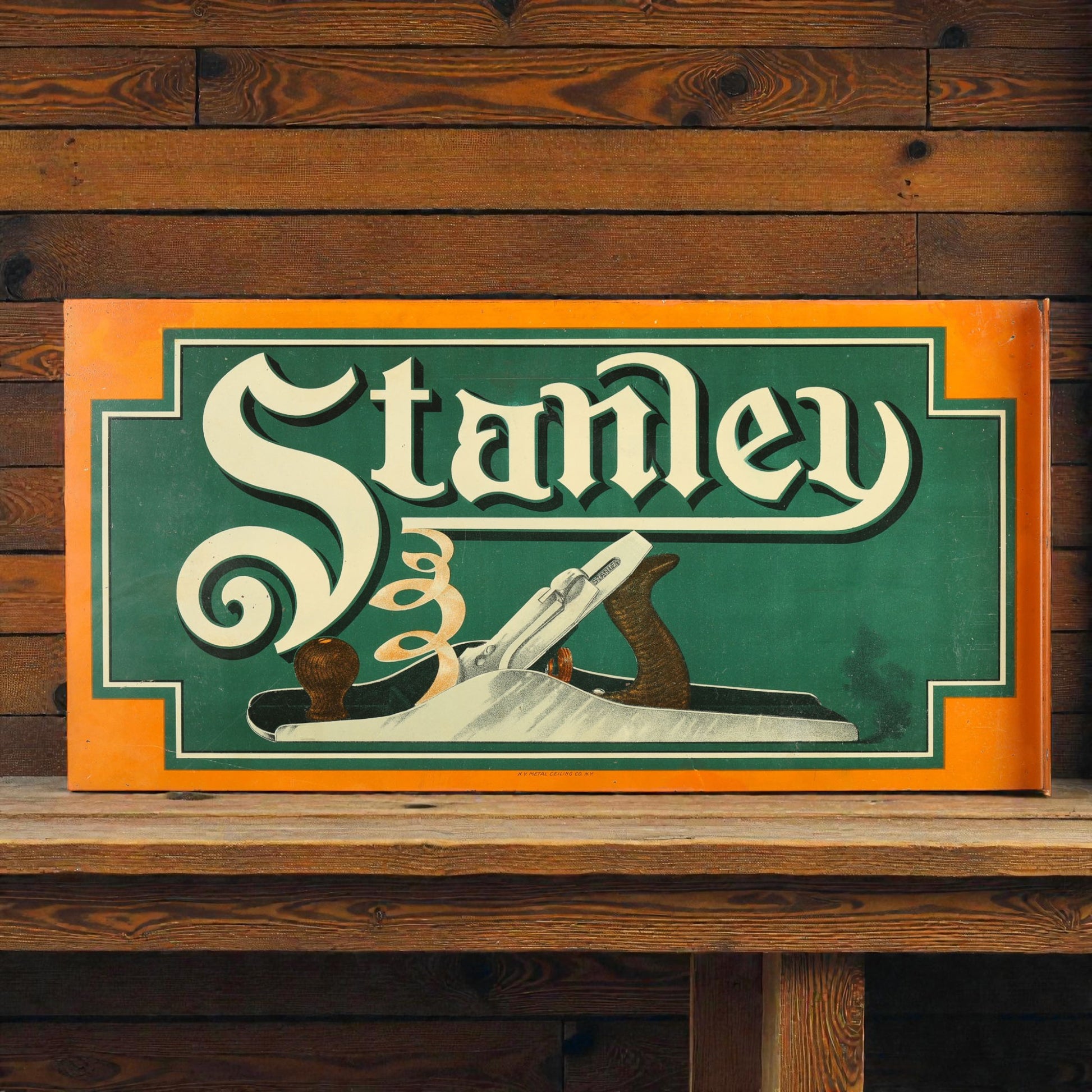Vintage-style 'Stanley' sign with a plane graphic on a wooden surface and background