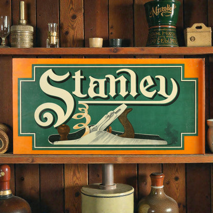 Vintage-style 'Stanley' sign on a wooden shelf with rustic decor.