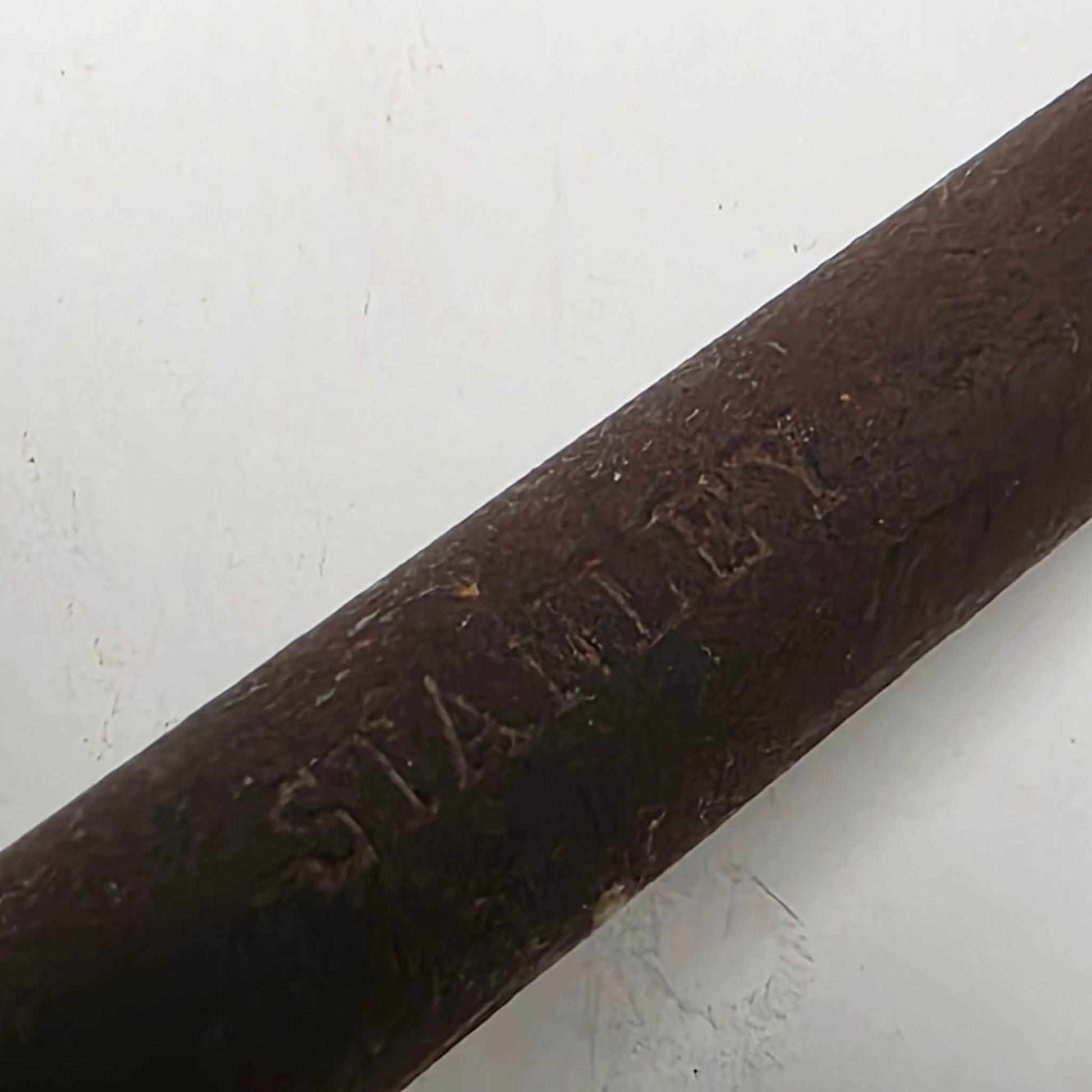 A close-up of a dark brown wooden stick or rod with the brand name 'STANLEY' embossed on it, set against a plain off-white background.