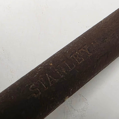 A close-up of a dark brown wooden stick or rod with the brand name 'STANLEY' embossed on it, set against a plain off-white background.