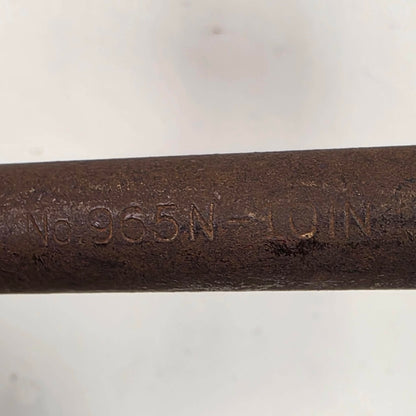 A close-up of a dark brown cast iron or steel rod stamped with the alphanumeric code 'No. 965N - LOIN' on a light gray background.
