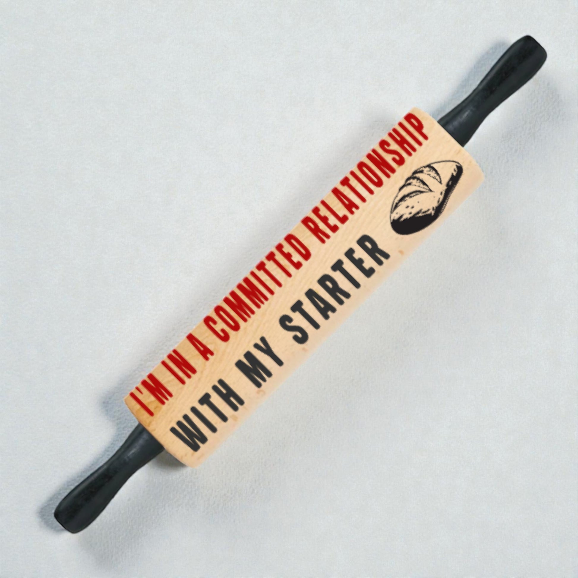 Rolling pin with humorous text on a light gray background