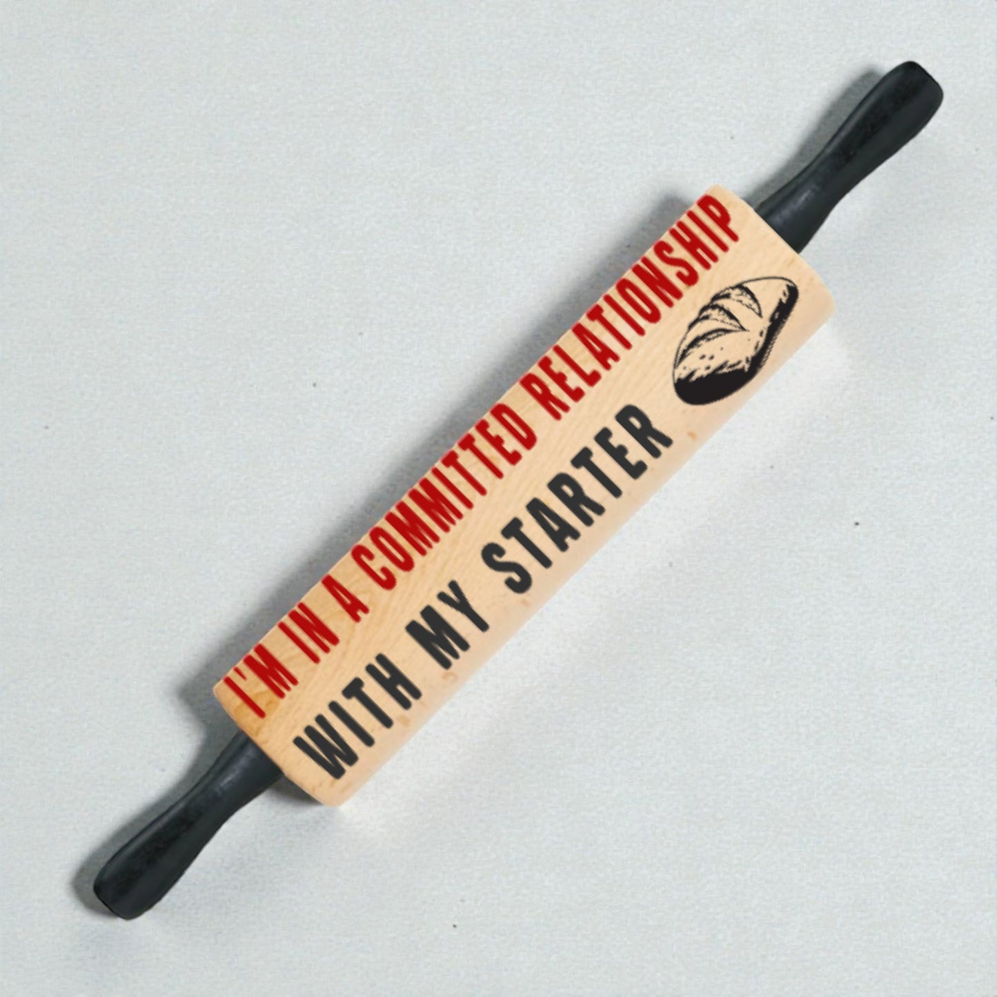 Pun-themed rolling pin with text and bread graphic on a light gray background