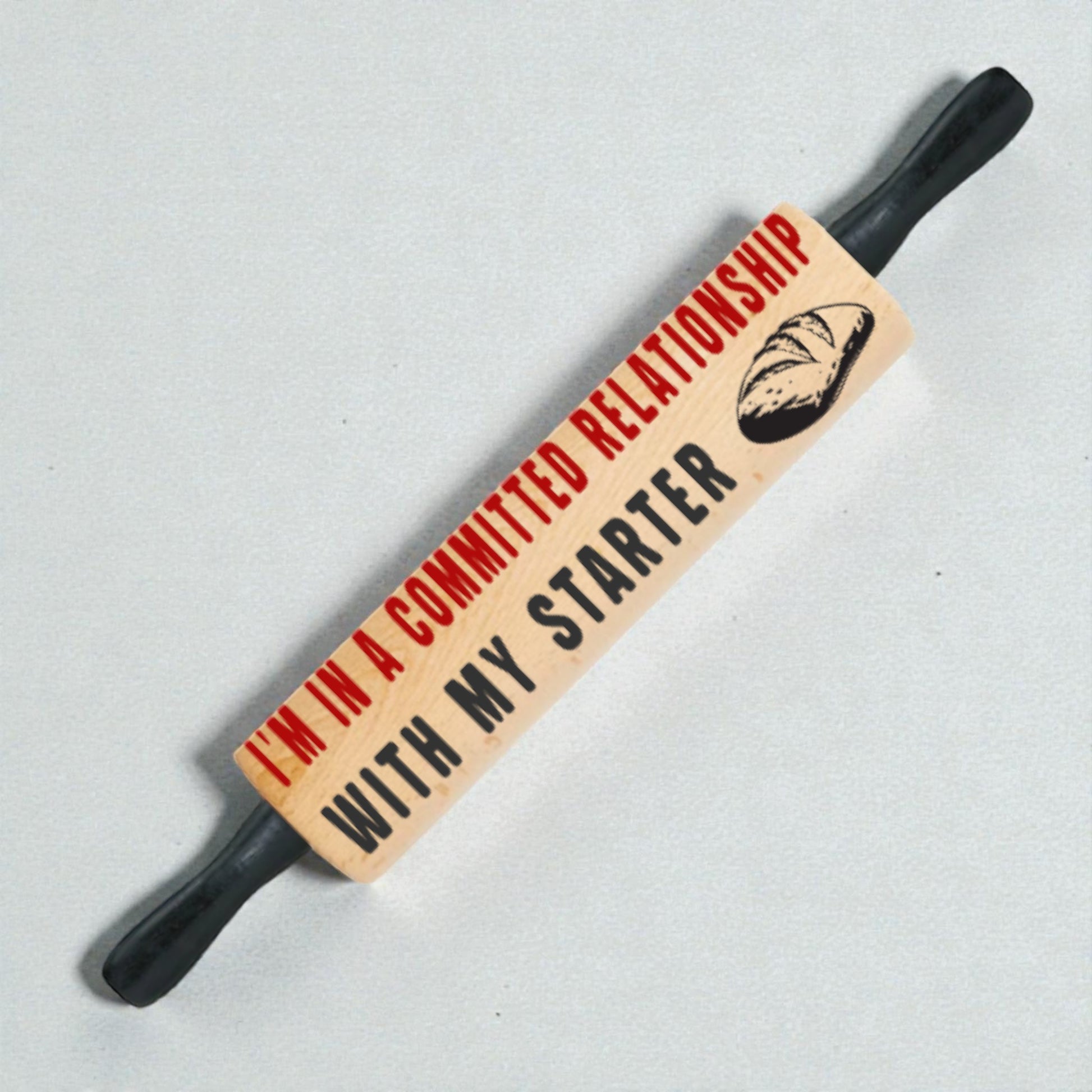 Pun-themed rolling pin with text and bread graphic on a light gray background