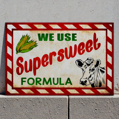 Vintage-style sign with a cow and corn illustration on a gray wall.