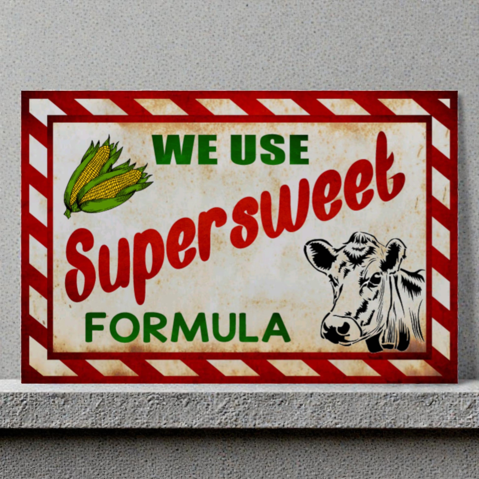 Vintage-style sign with a cow illustration and text about 'Supersweet Formula' on a gray background.