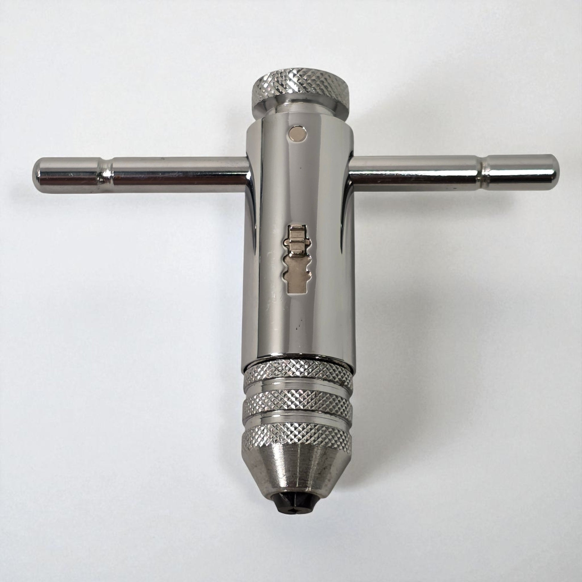 Metal drill bit and wrench on a white background