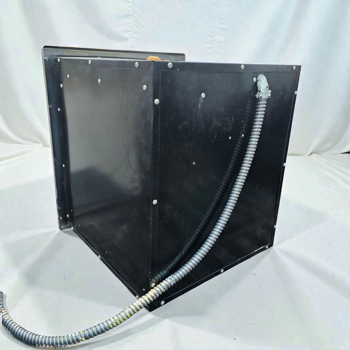 Black metal enclosure with a hose on a white background