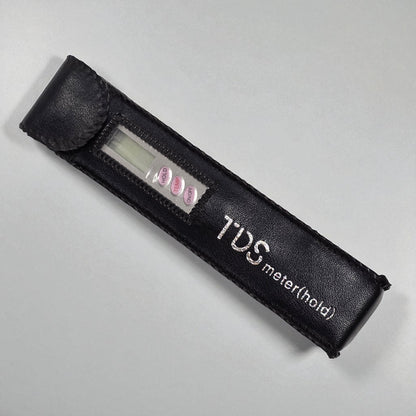 Black TDS meter with digital display on a gray background