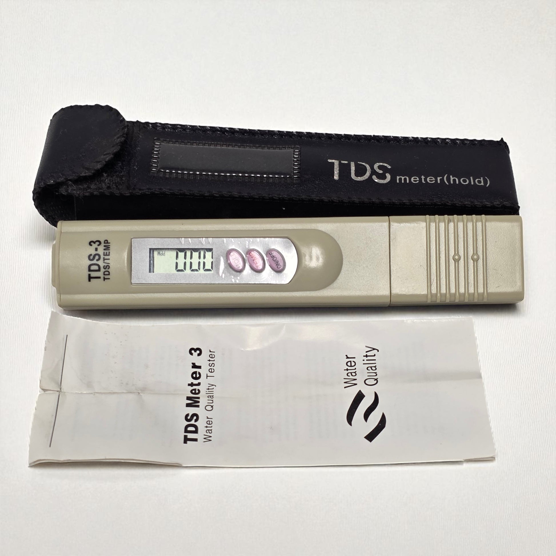 TDS meter with carrying case and manual on a white background