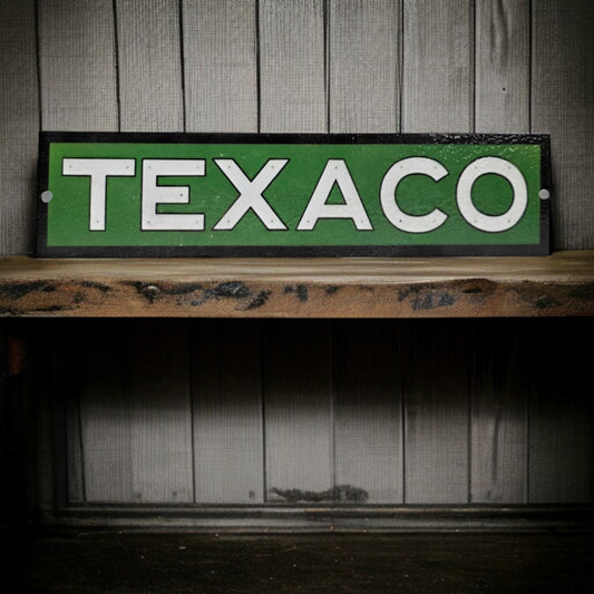Vintage Texaco sign on a wooden shelf with a wooden paneled background