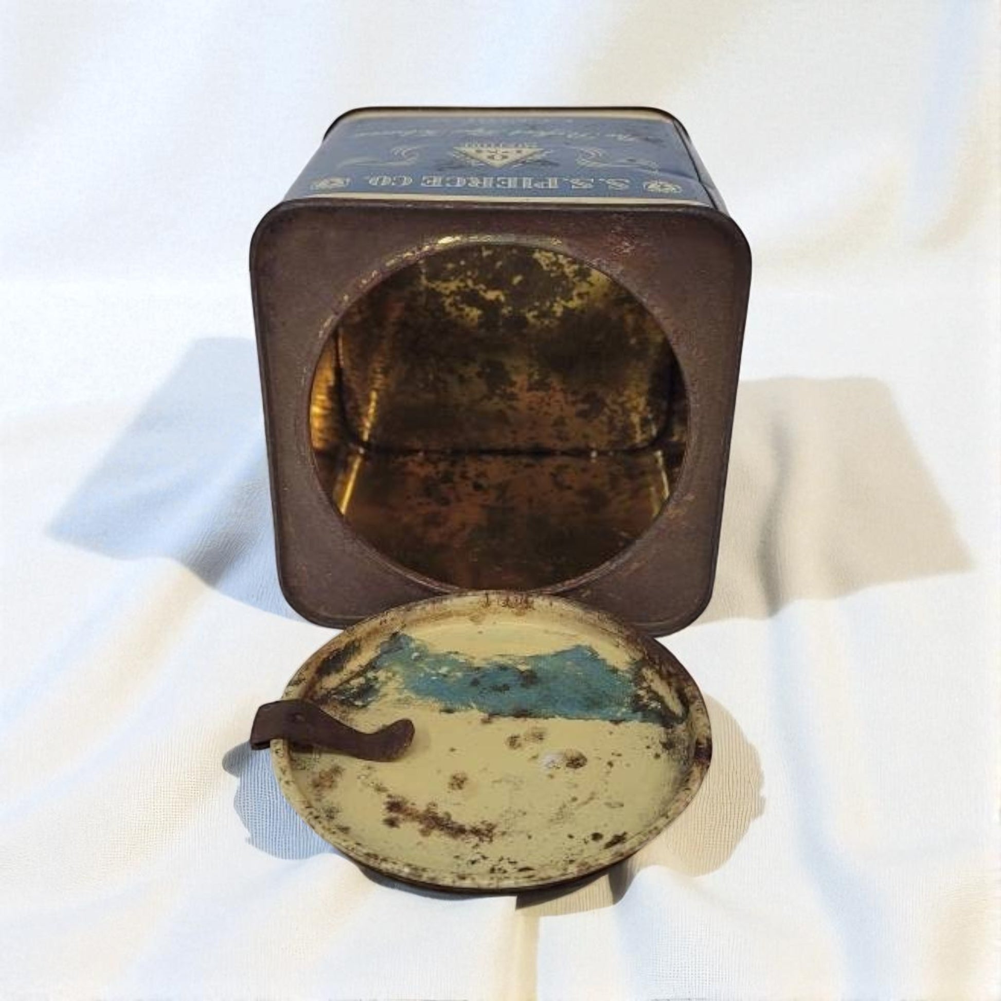 Vintage tin with a round, rusted lid on a white background