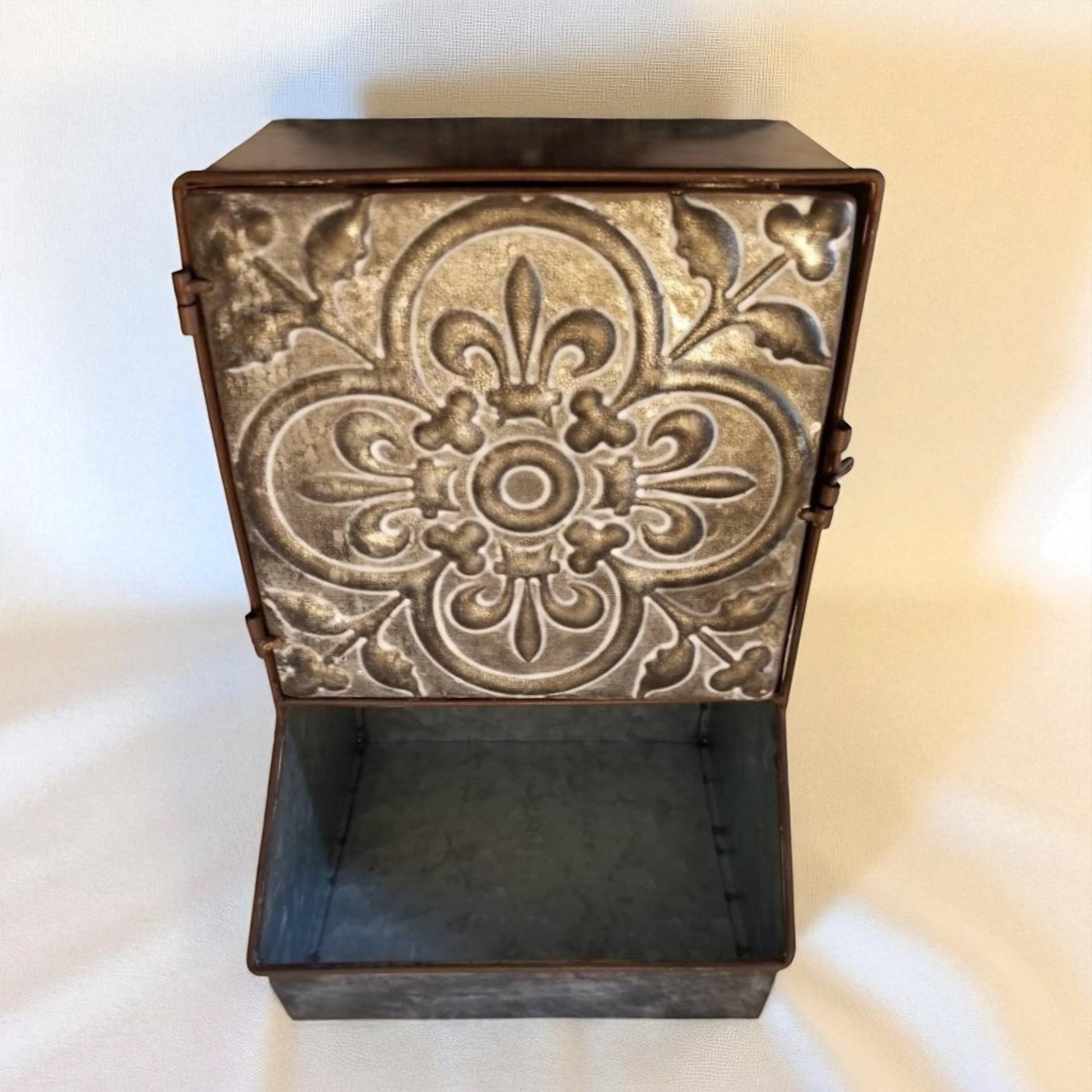 Decorative metal box with intricate patterns on a white background