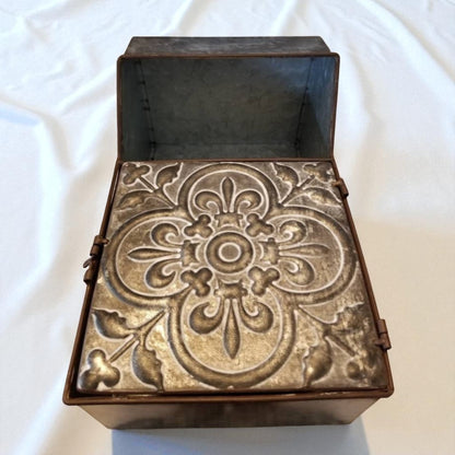 Decorative metal box with intricate patterns on a white background