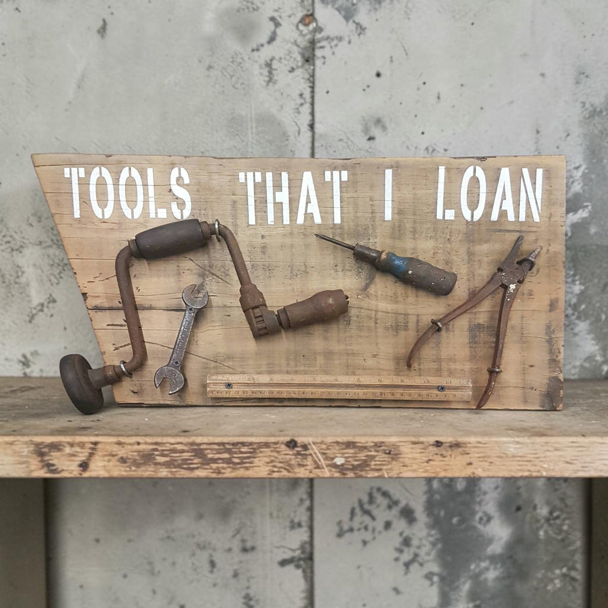 Handmade rustic Tools That I Loan garage sign with five useless tools

